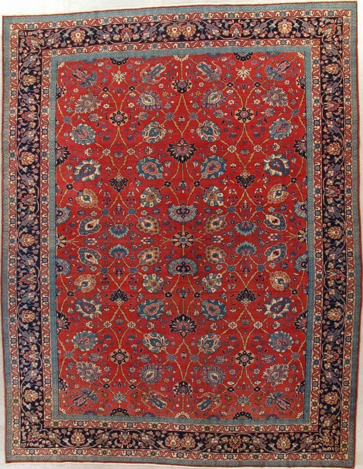 A red rug with a blue border and flowers on it