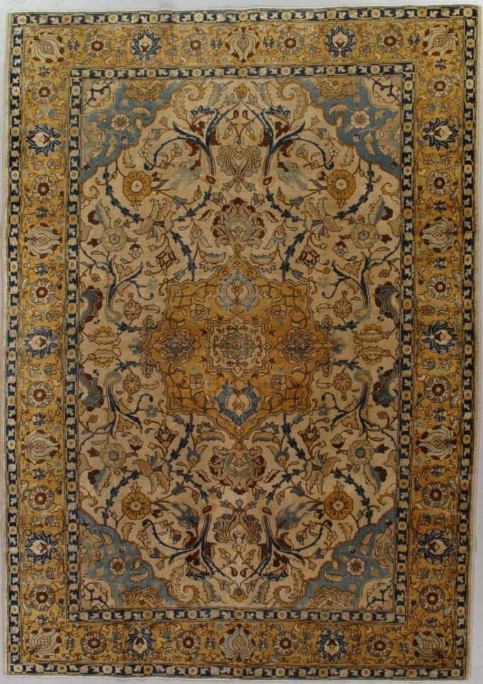 A rug with a floral pattern on it is hanging on a wall.
