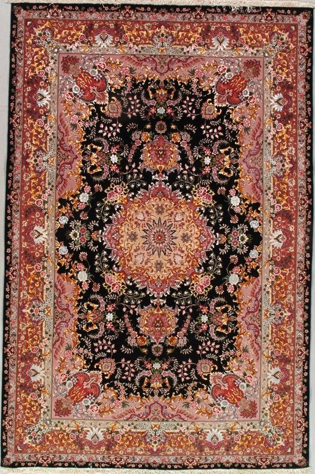 A rug with a floral pattern on it is hanging on a wall.