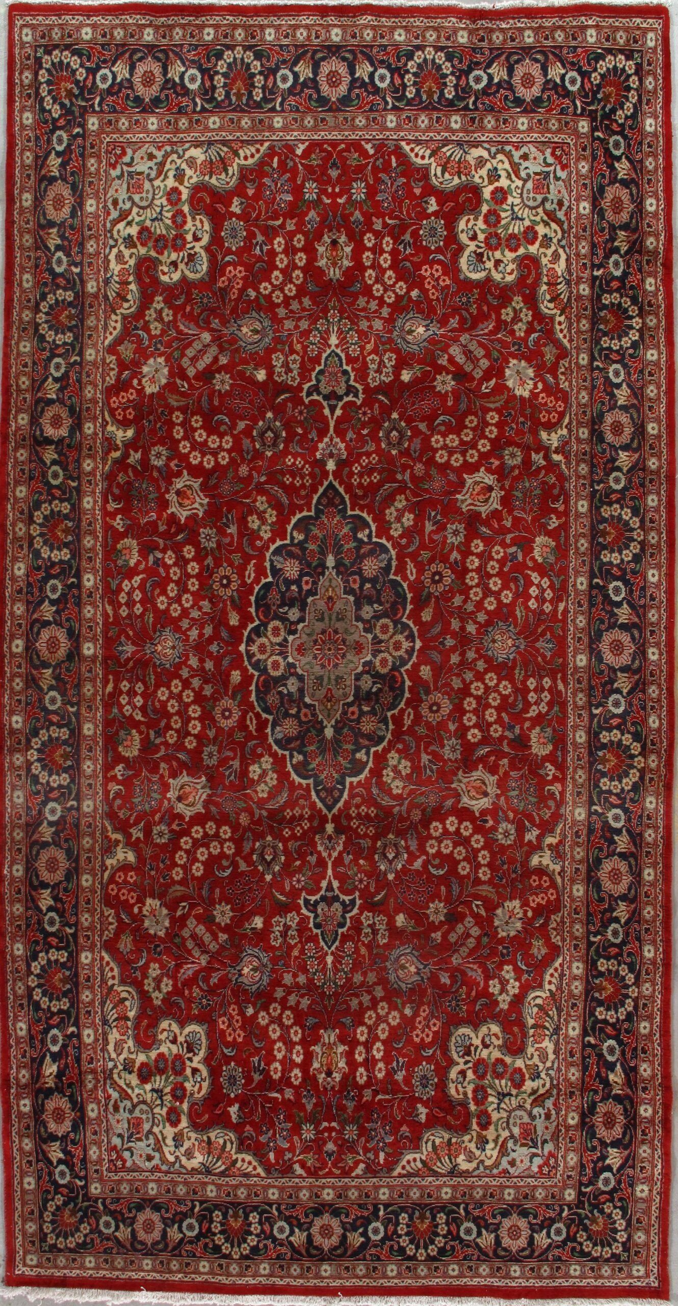 A red rug with a floral pattern on it is sitting on a table.