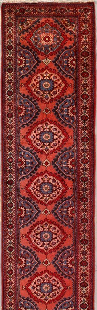 A red rug with a pattern on it is sitting on a table.