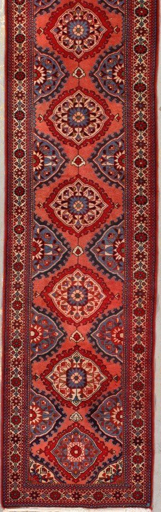 A red rug with a pattern on it is sitting on a table.