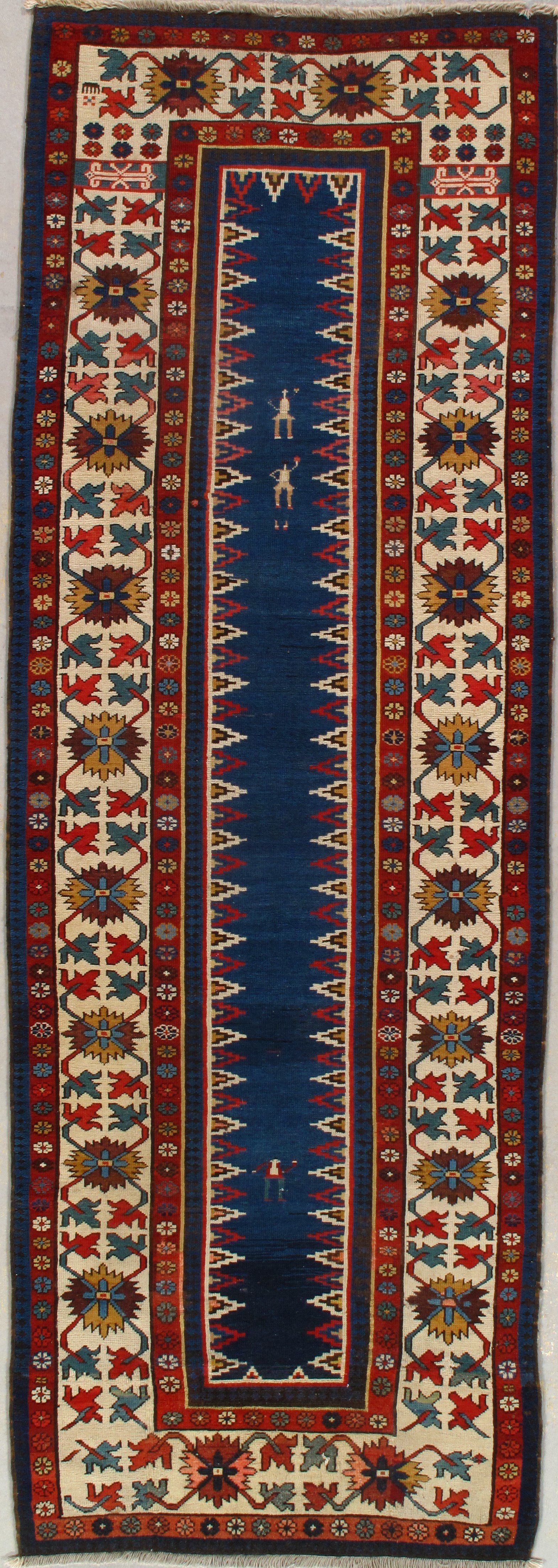 A colorful rug with a blue border is sitting on a white surface.