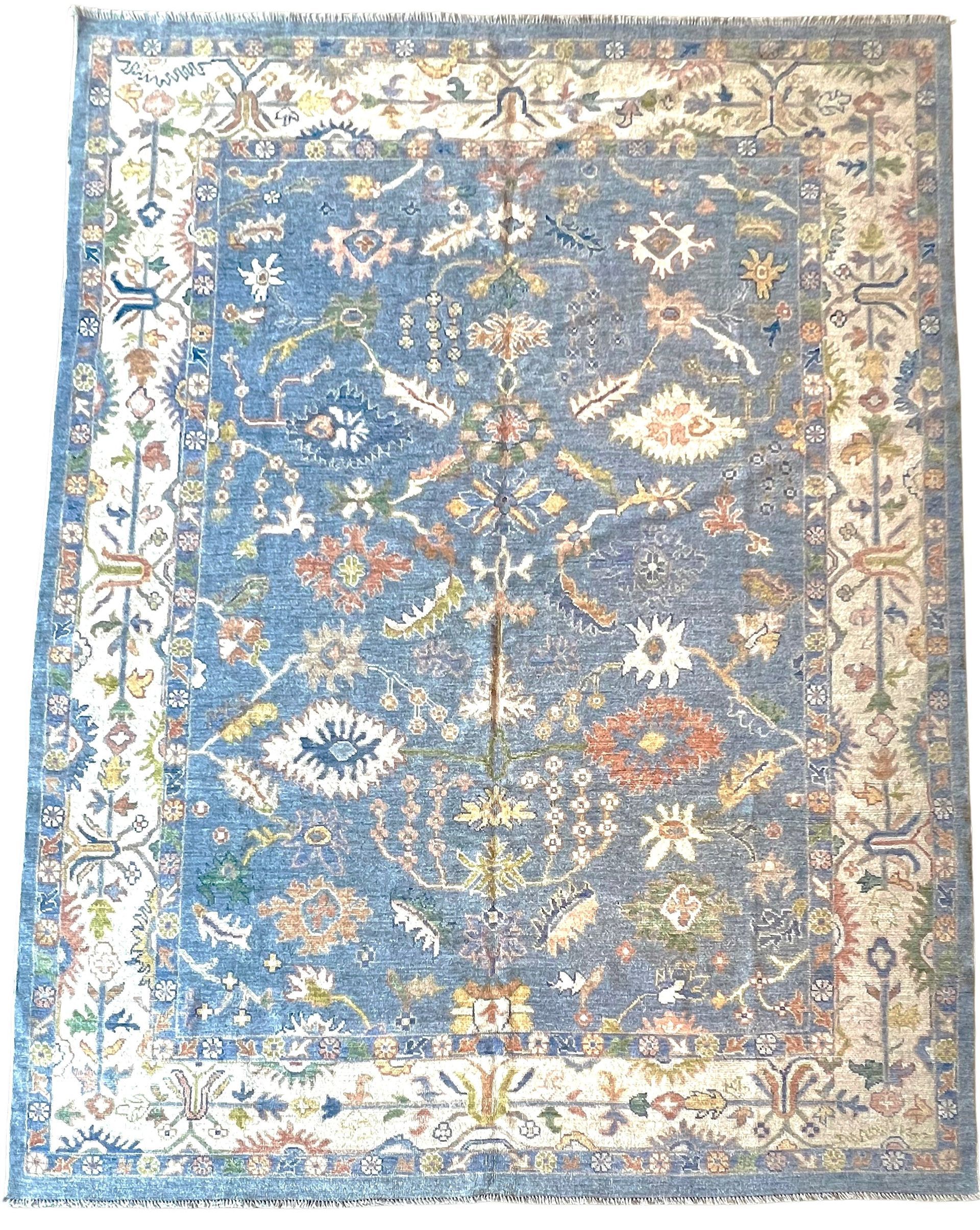 A blue and white rug with a floral pattern on a white background.