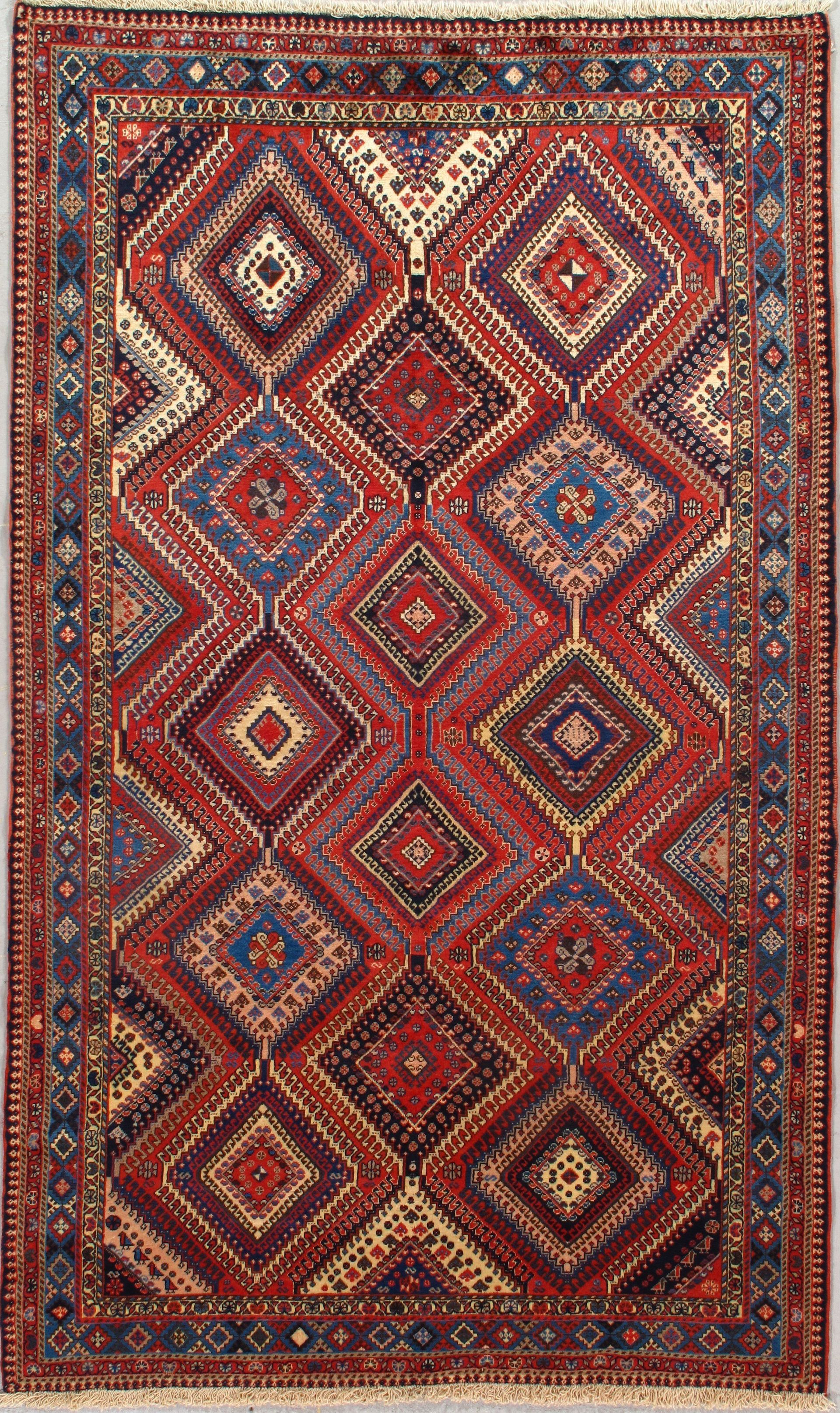 A rug with a geometric pattern on it is hanging on a wall.