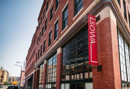 A large brick building with a red sign that says lsowa on it.