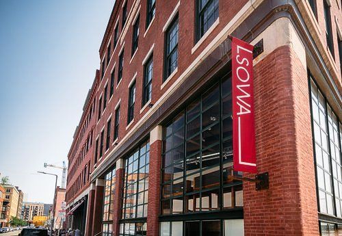 A large brick building with a red sign that says lsowa on it.