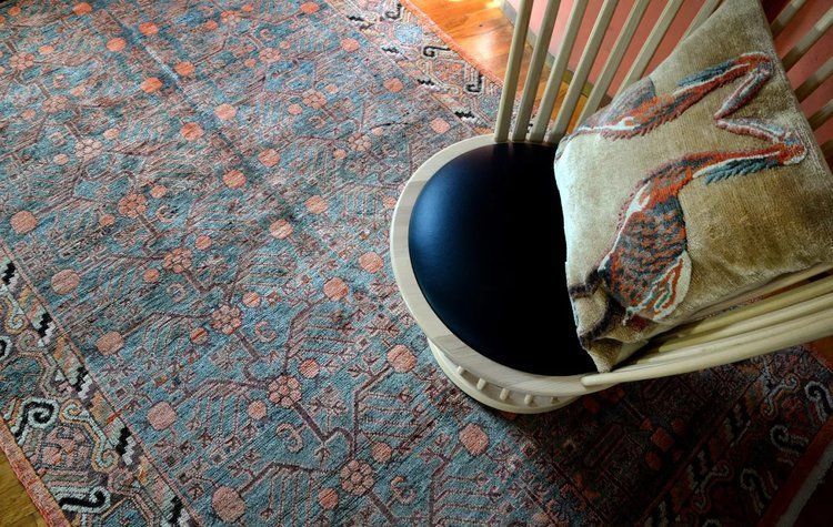 A chair is sitting on a rug next to a bowl.