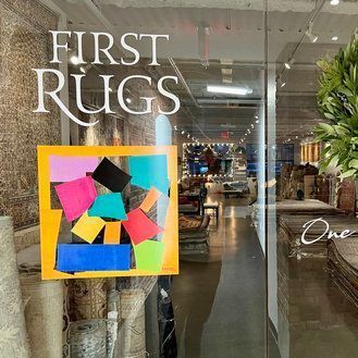 A store front with a sign that says first rugs