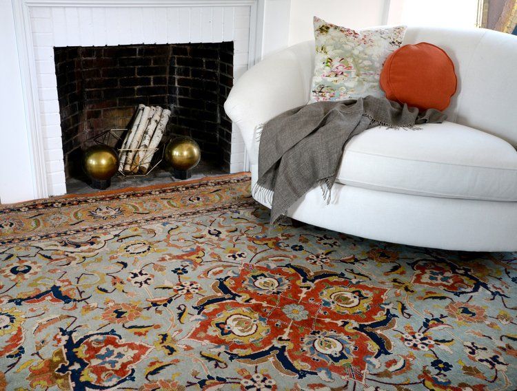 A white chair is sitting in front of a fireplace in a living room.