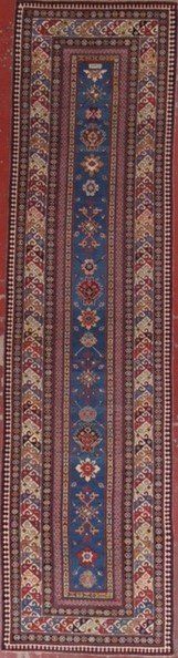 A rug with a blue and red pattern is sitting on a red surface.