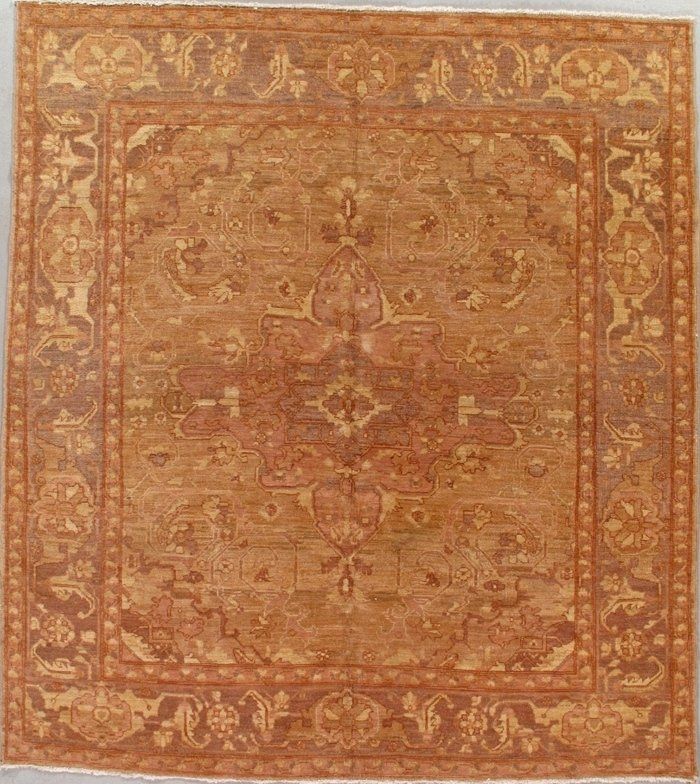 A brown rug with a pattern on it is hanging on a wall.