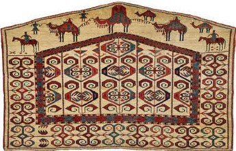 A rug with camels and people riding horses on it.
