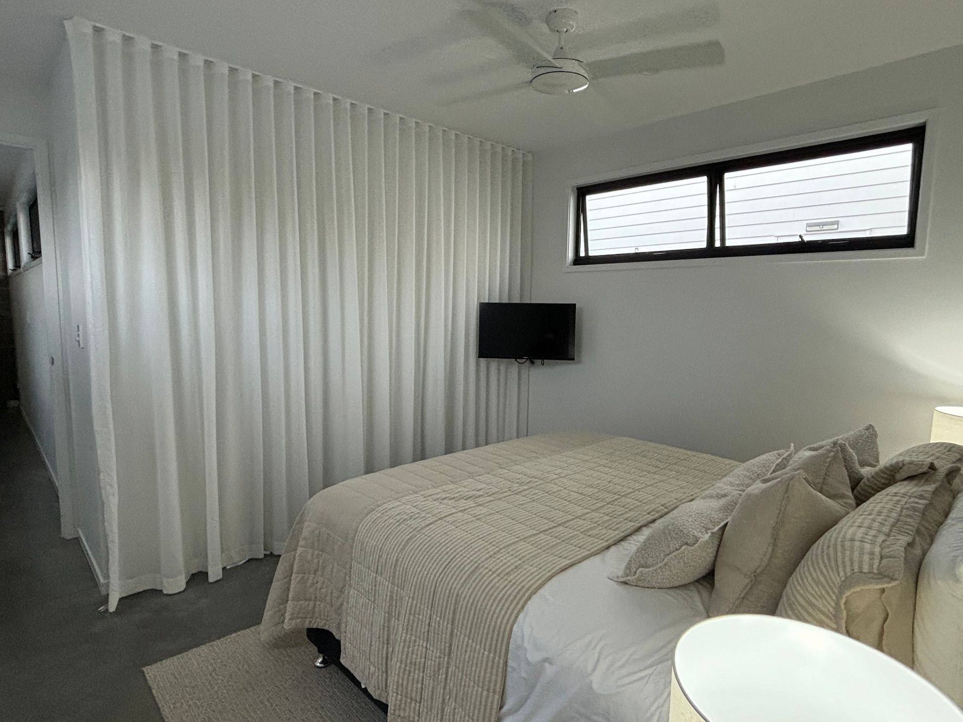 A White Curtain Is Hanging on A Window in A Room — Curtain Concepts in Dunbible, NSW