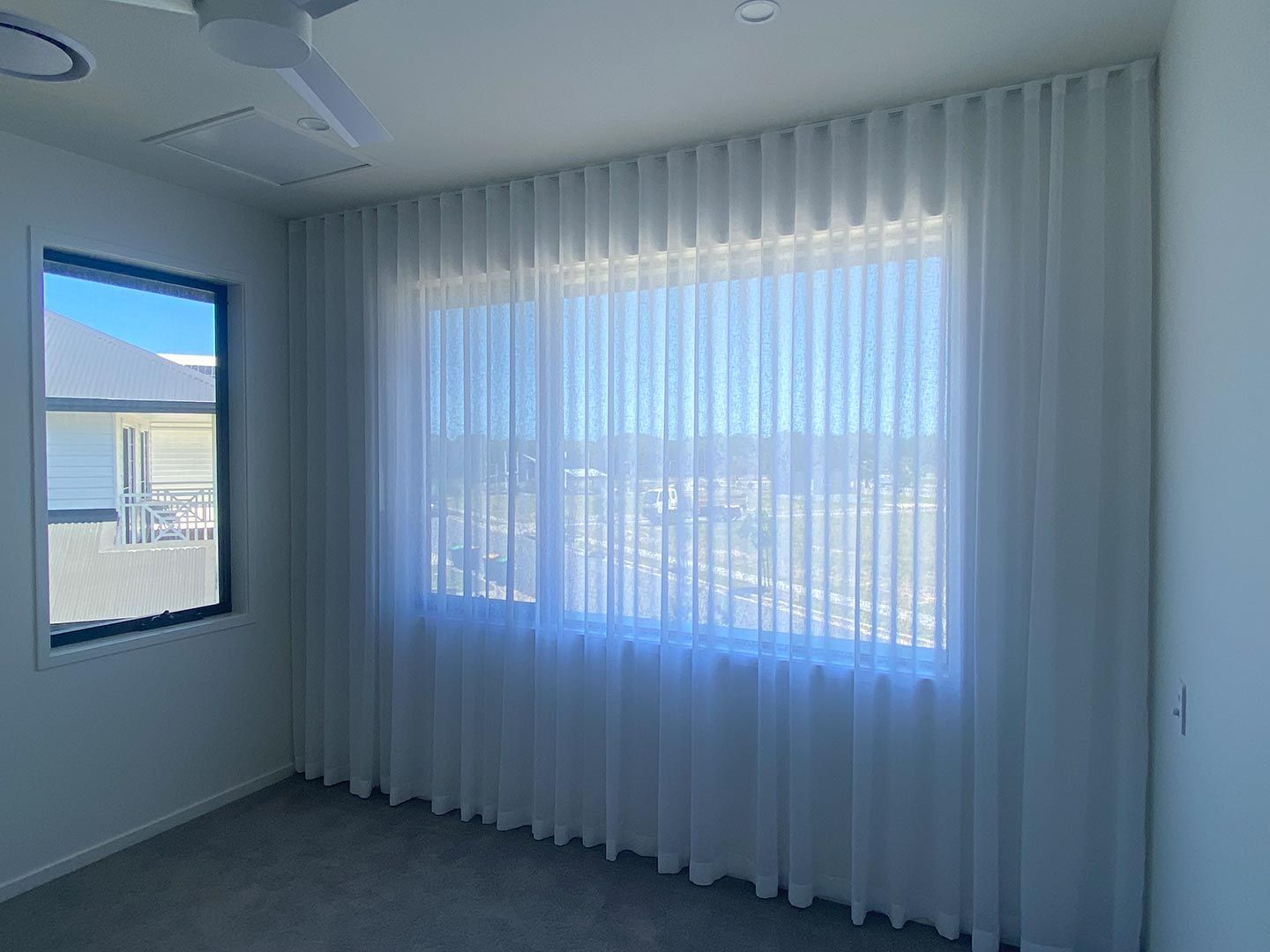 A Bedroom With a Large Window and White Curtains — Curtain Concepts in Terranora, NSW