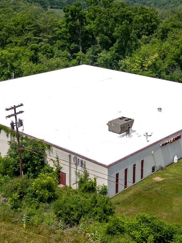 An aerial view of a building with a white roof