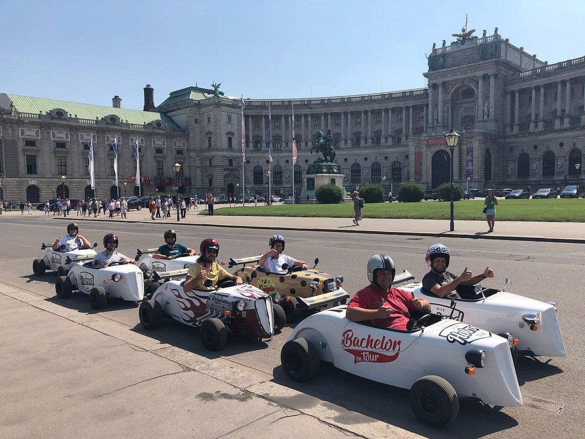 Fahrer mit Sonnenbrille posiert im Hotrod vor dem Burgtheater für ein Erinnerungsfoto