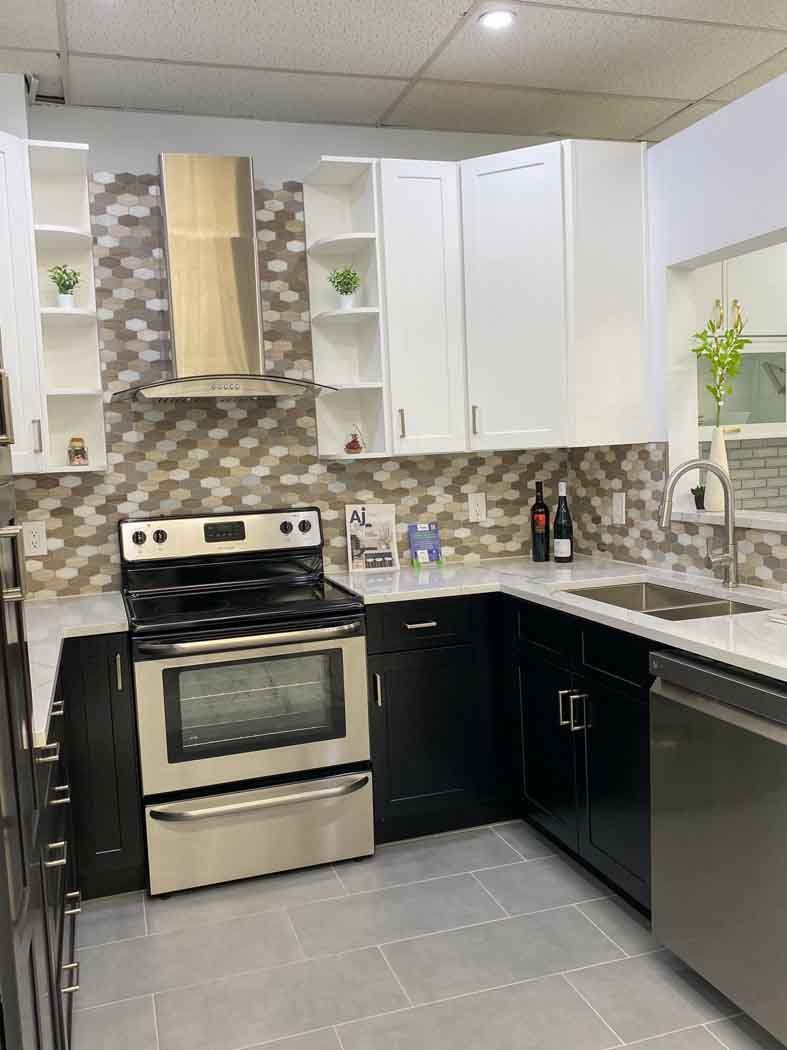 Modern kitchen featuring white upper cabinets, black lower cabinets, stainless steel appliances, and a decorative tiled backsplash.