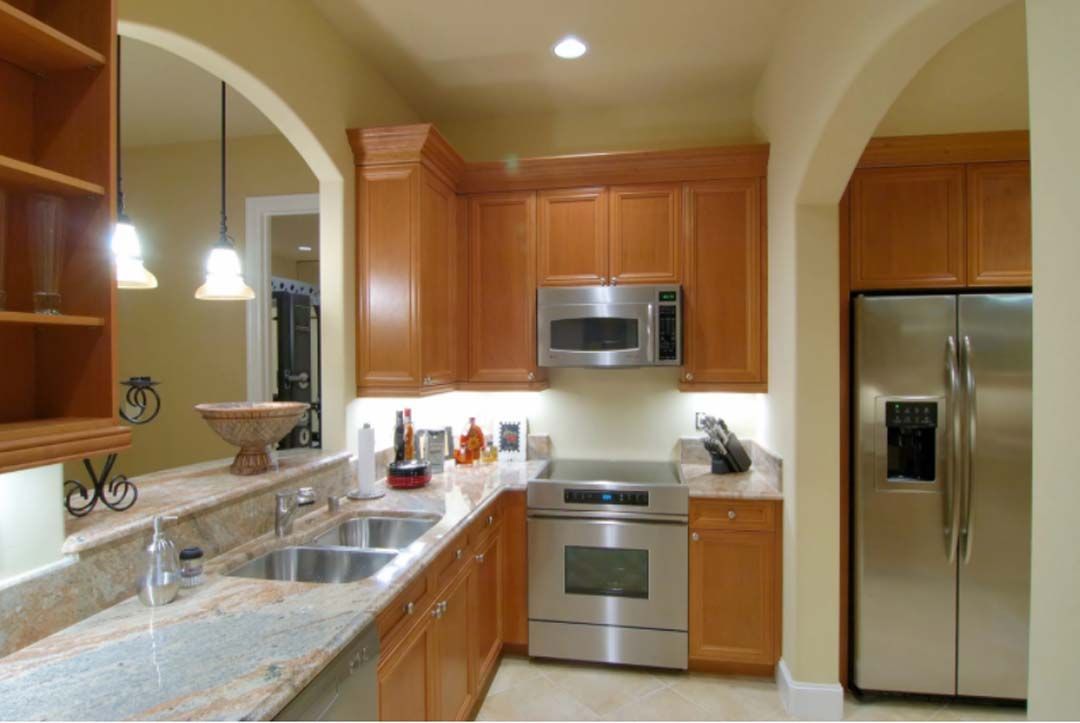 Kitchen with light brown cabinets, stainless steel appliances, and granite countertops.