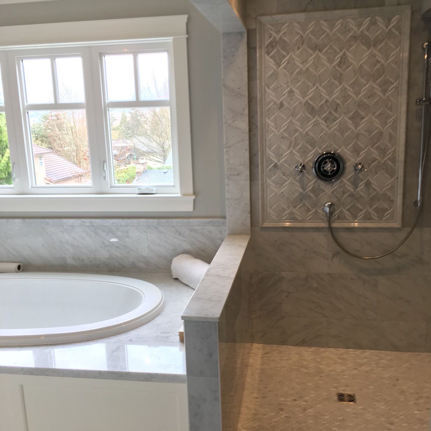 A bathroom with a tub and a shower with a window