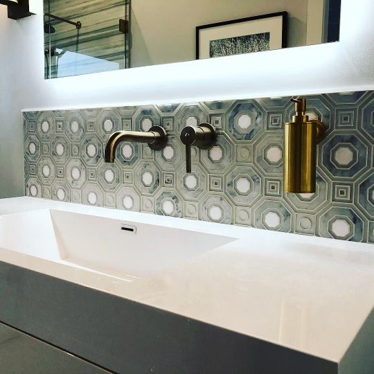 A bathroom sink with a mirror and a soap dispenser