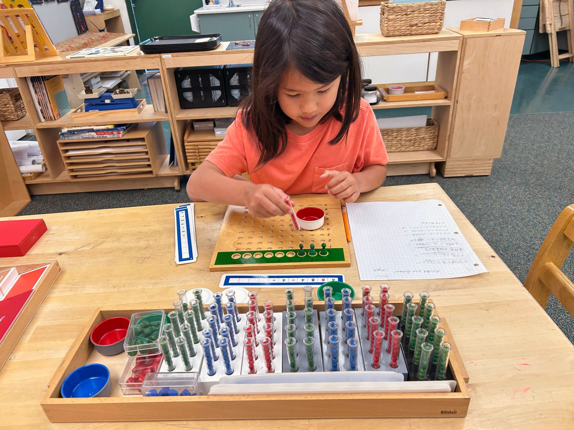 Child working with the Montessori division board.