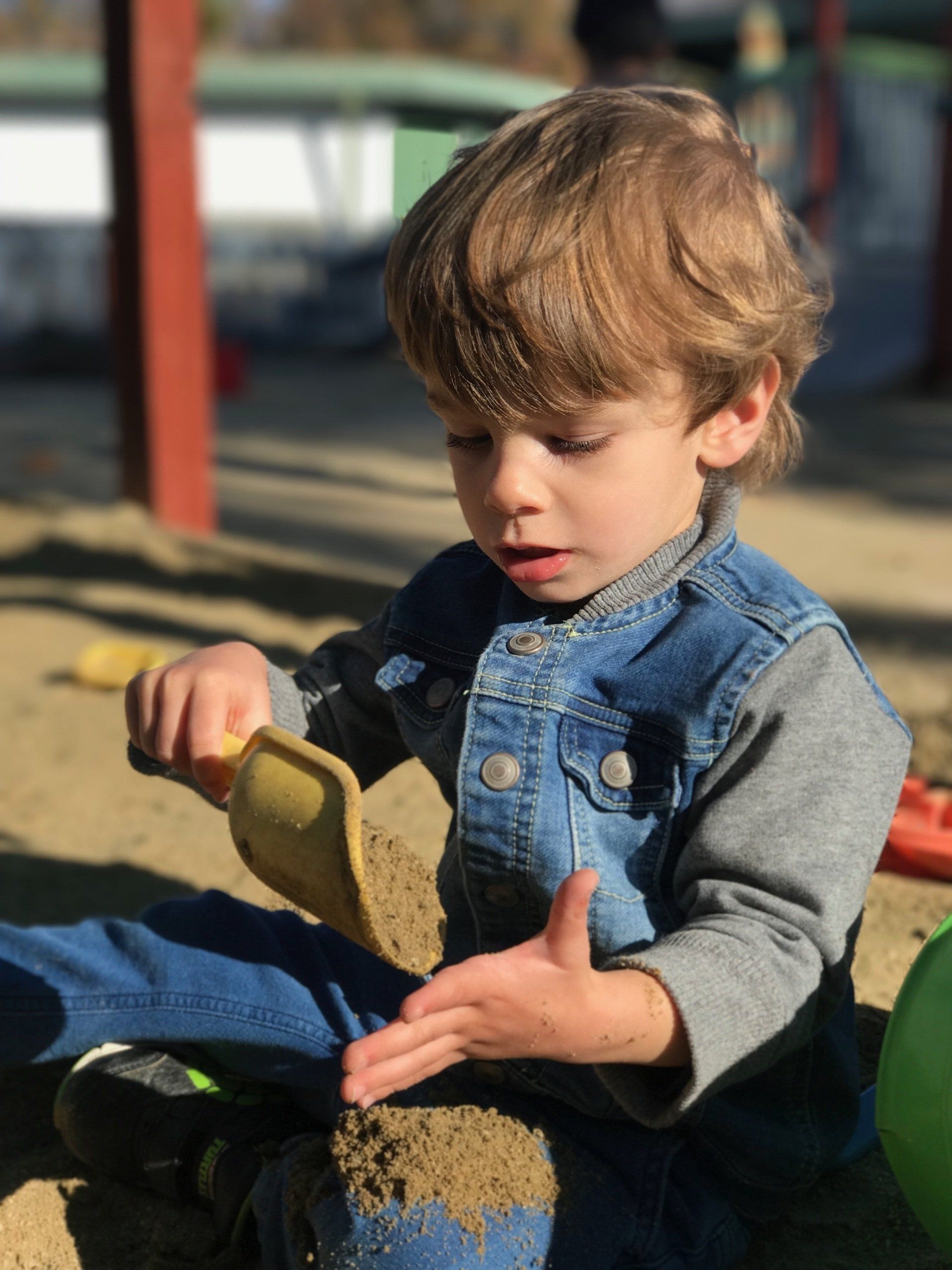 Montessori child digging in the sand.