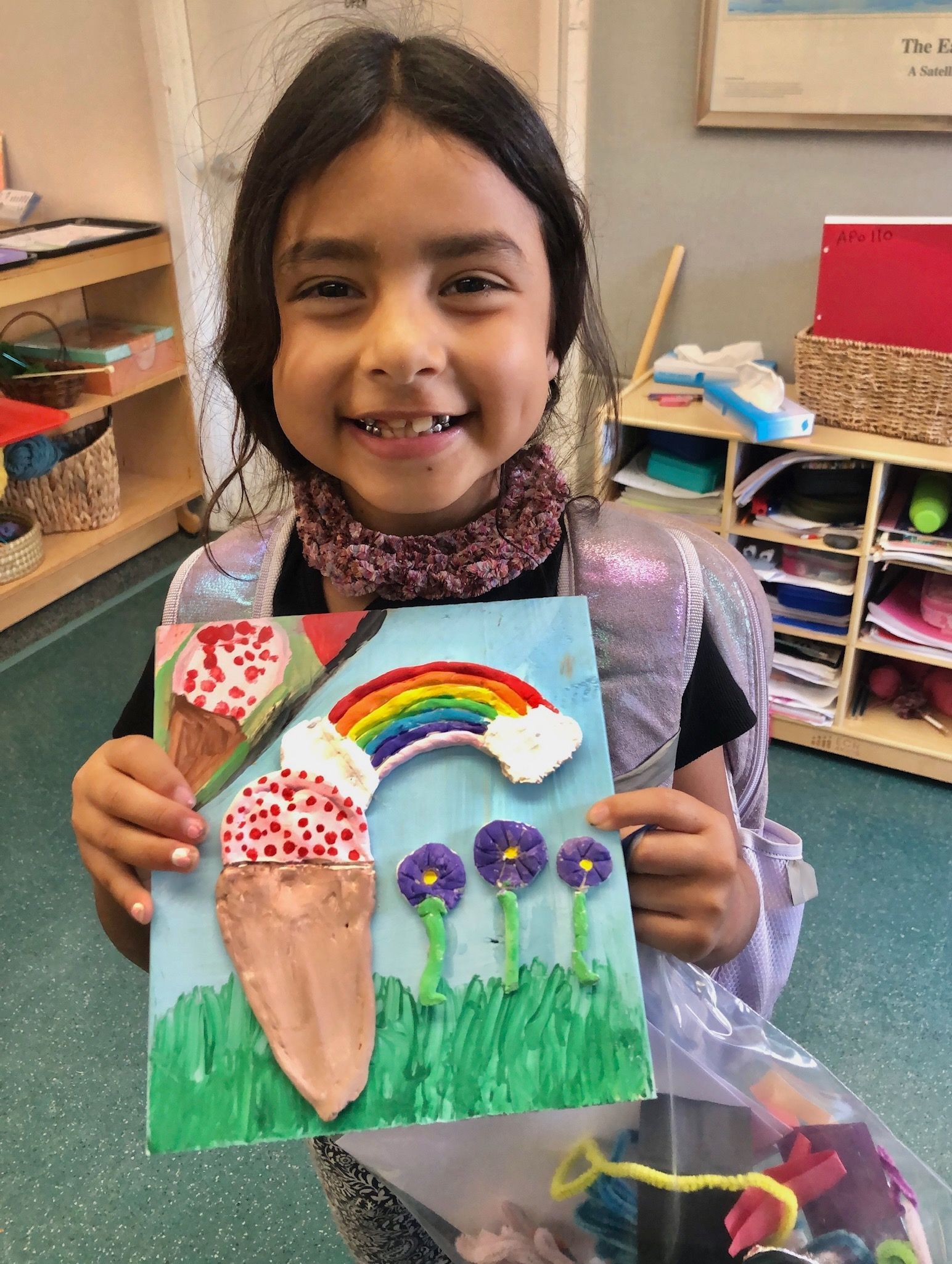 Montessori child holding artwork.