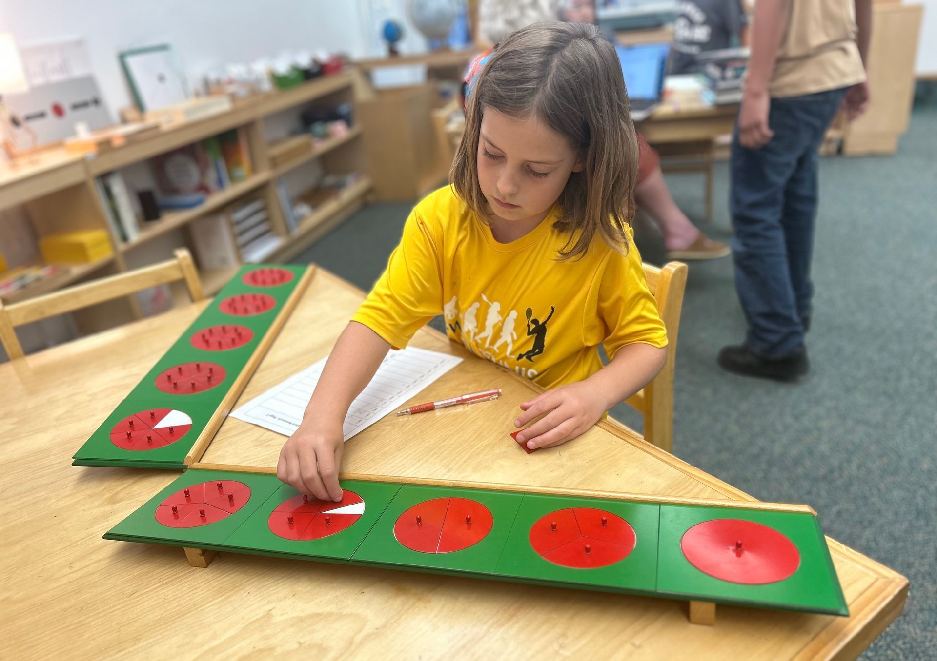 Child working with the Montessori  fractions puzzles board