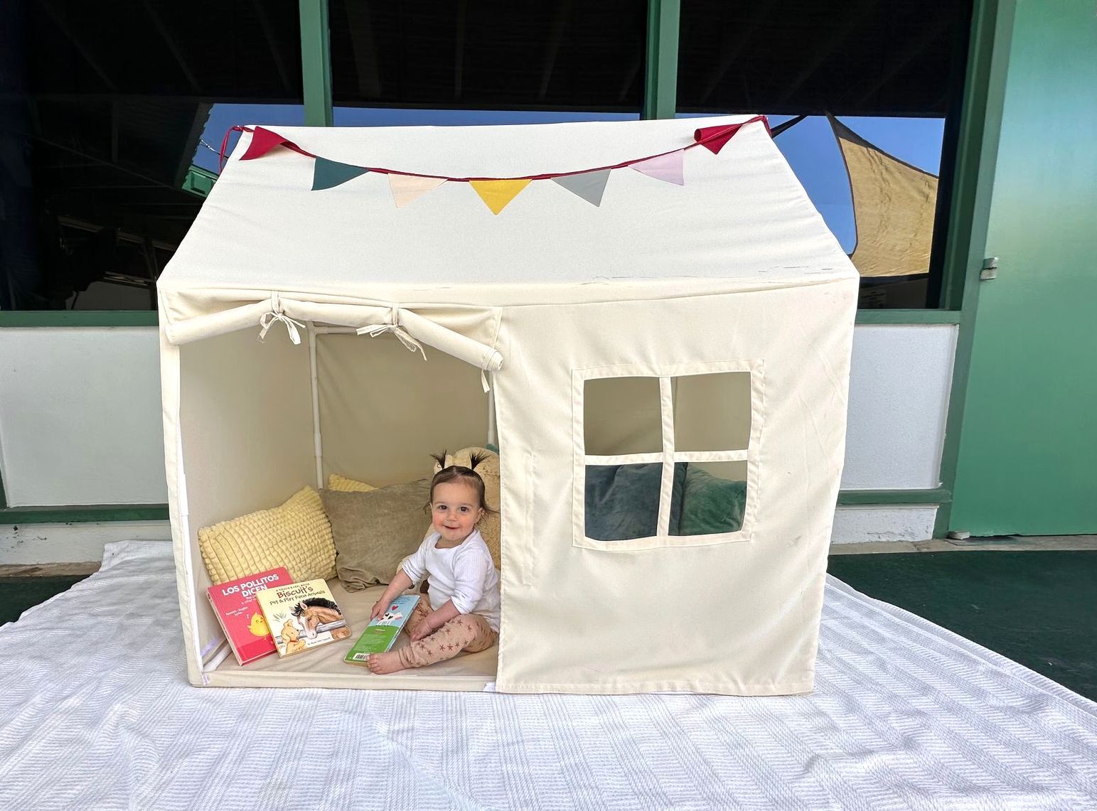 Montessori infant reading in a playhouse.
