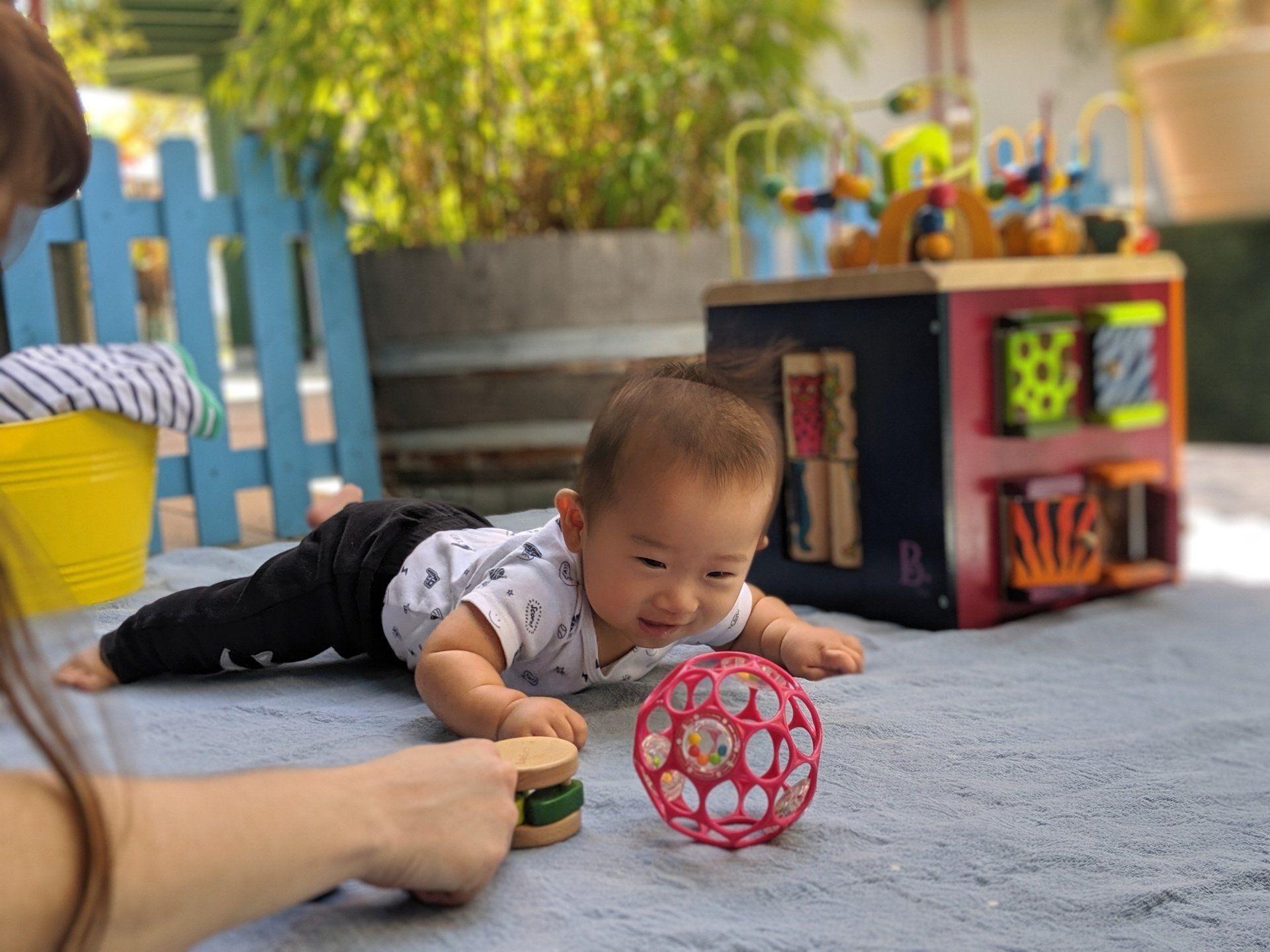 Montessori Infant and guide laying on a carpet and working with materials.