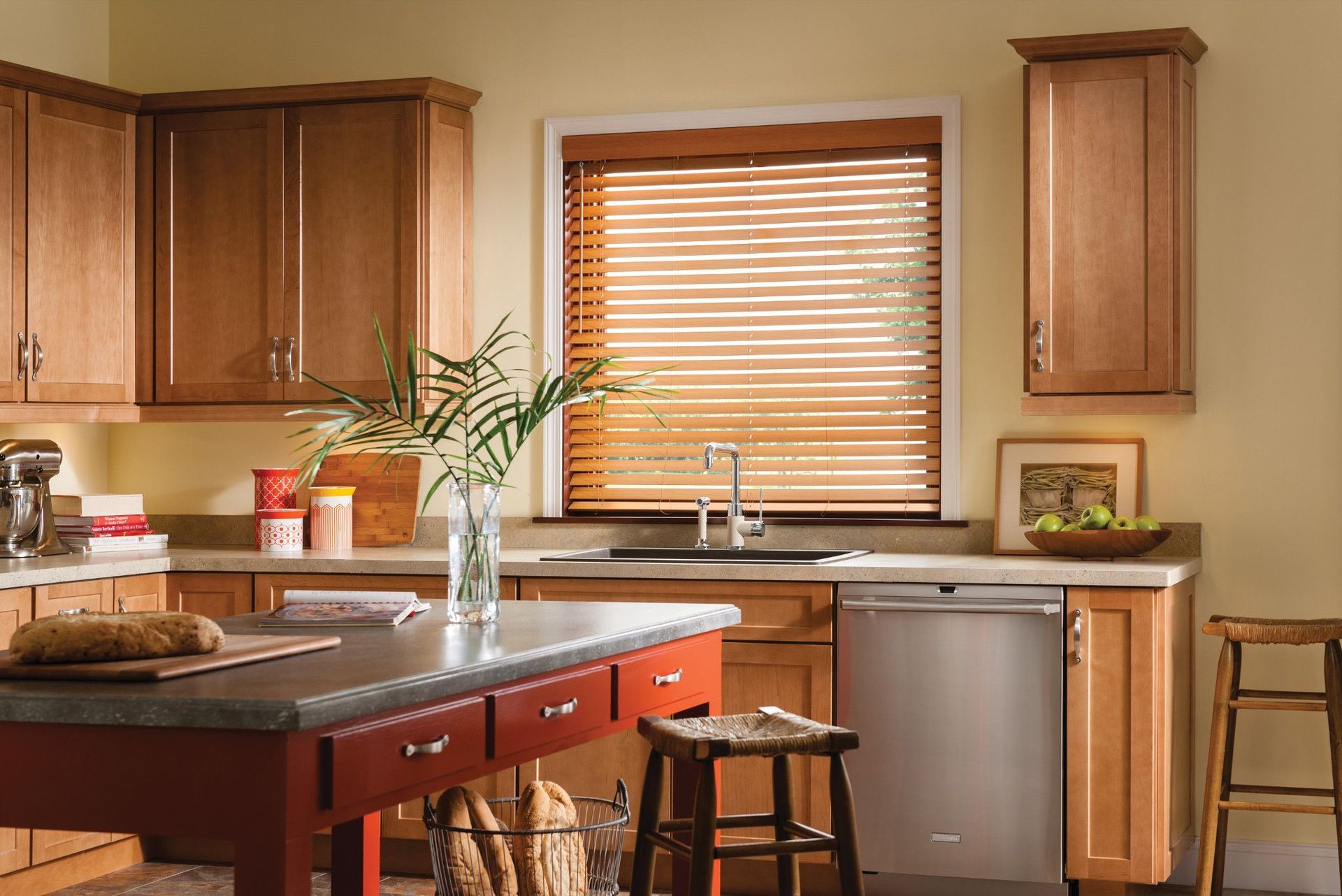 Kitchen with wooden cabinets, red island, stainless steel appliances, and blinds on the window.