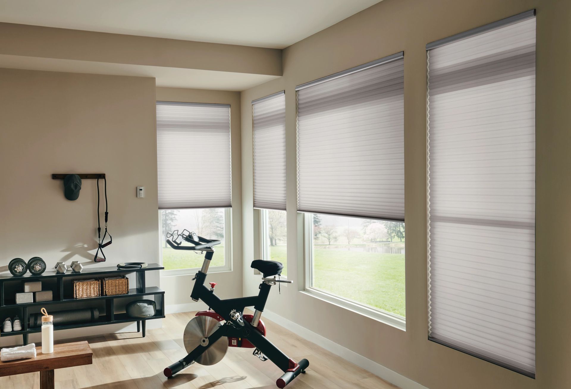 Home gym with exercise bike, workout equipment, and light-filtering shades.