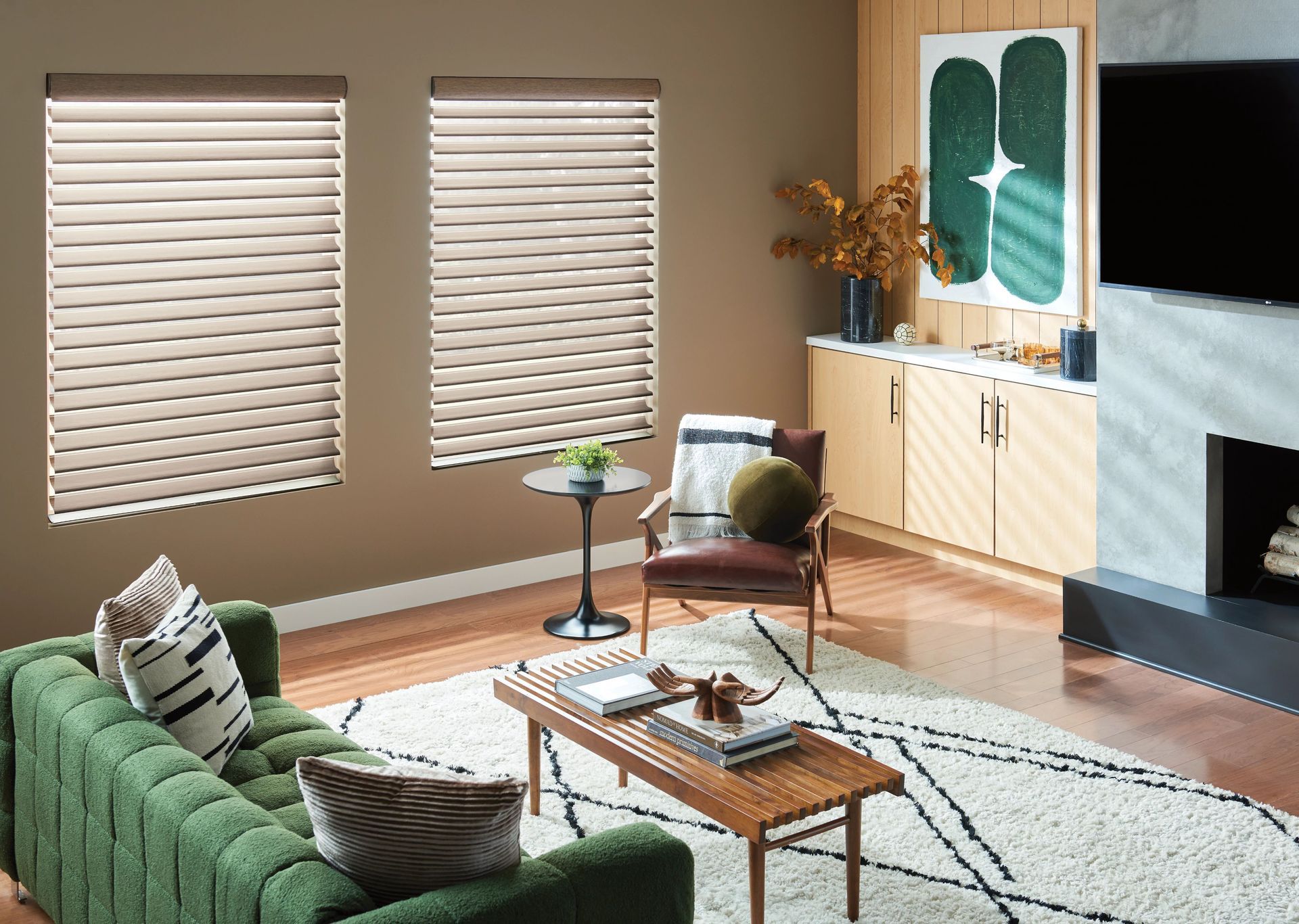 Living room with green sofa, wooden coffee table, armchair, and two windows with blinds.