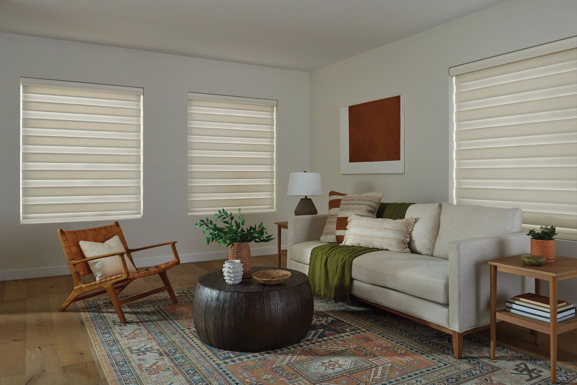 Living room with neutral tones, patterned rug, sofa, and blinds.