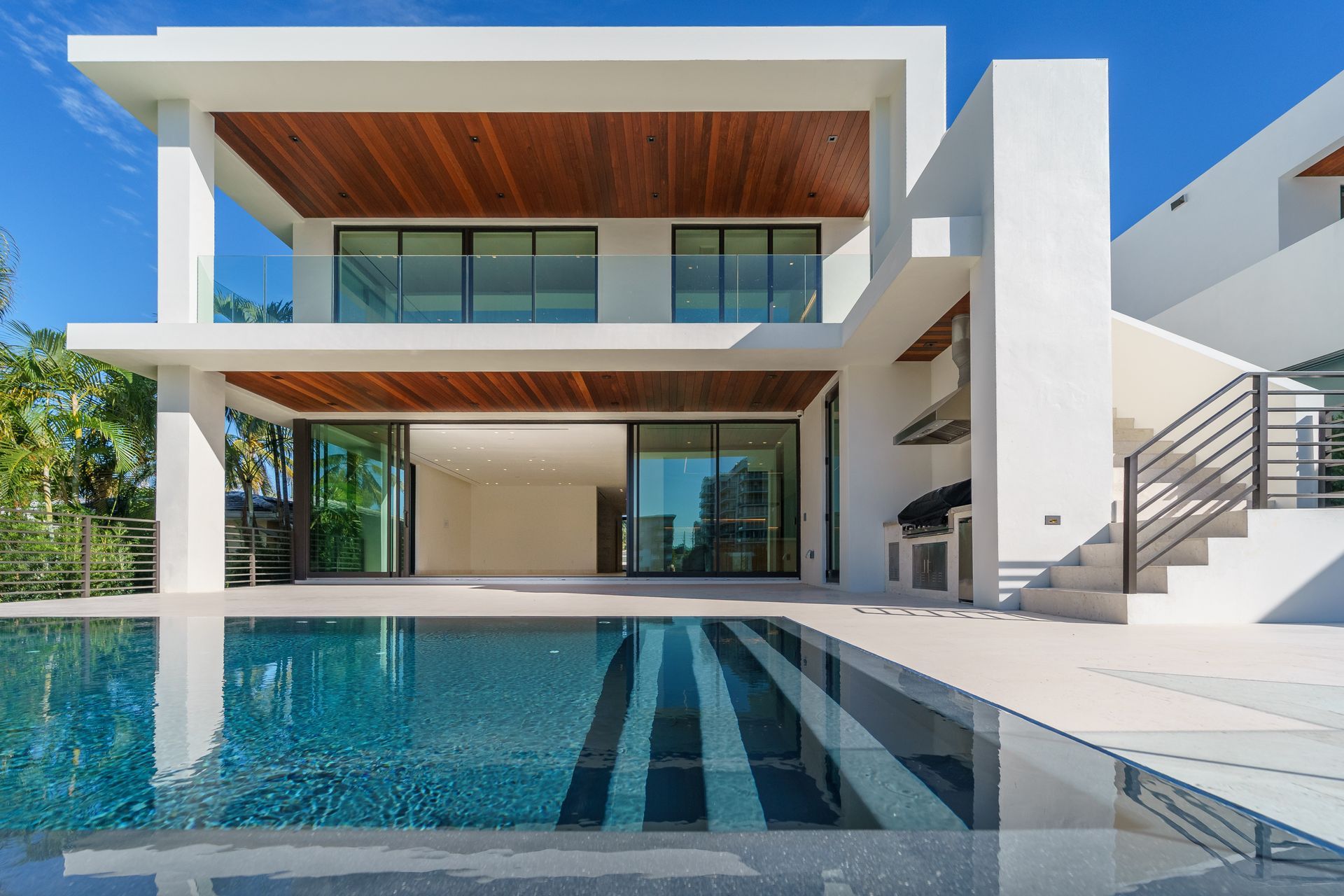 A modern, sleek swimming pool in a contemporary house with clean lines and blue water.