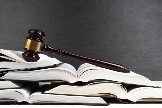 A judge 's gavel is sitting on top of a stack of books.