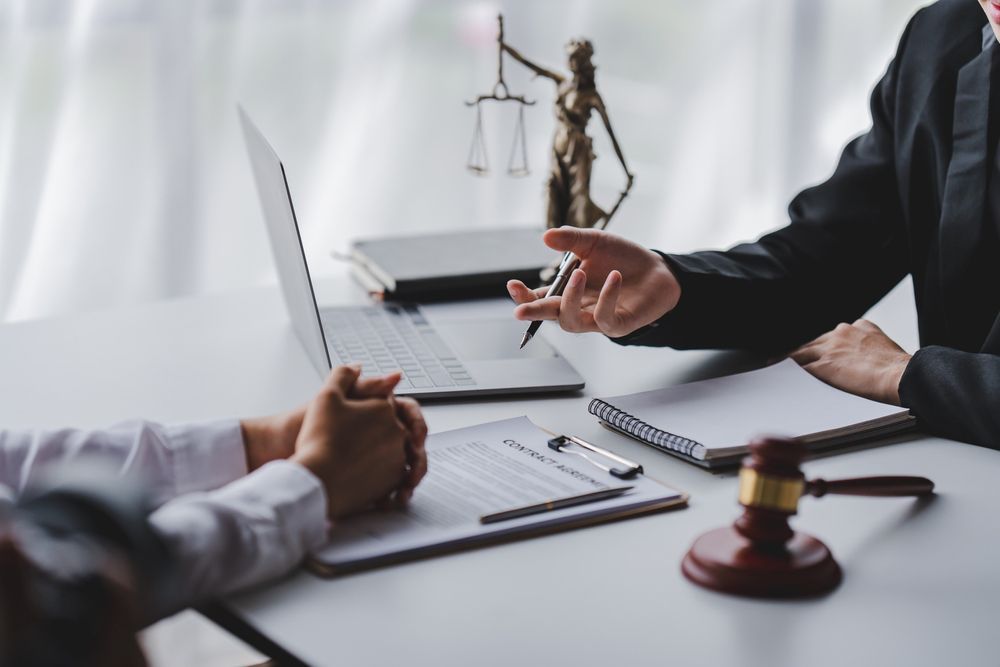 A judge is sitting at a table talking to a client.
