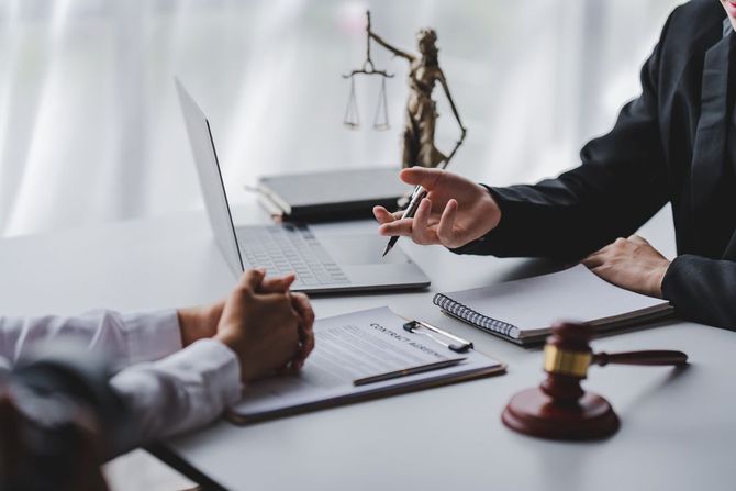 A judge is sitting at a table talking to a client.