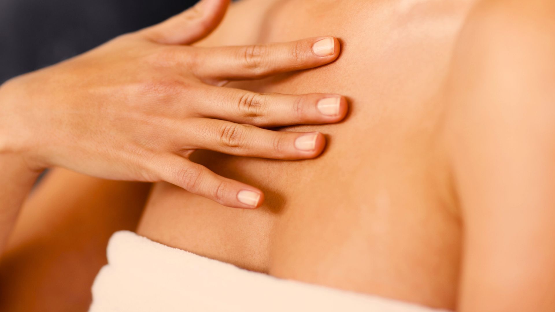 A woman is getting a massage with her hands on her back.