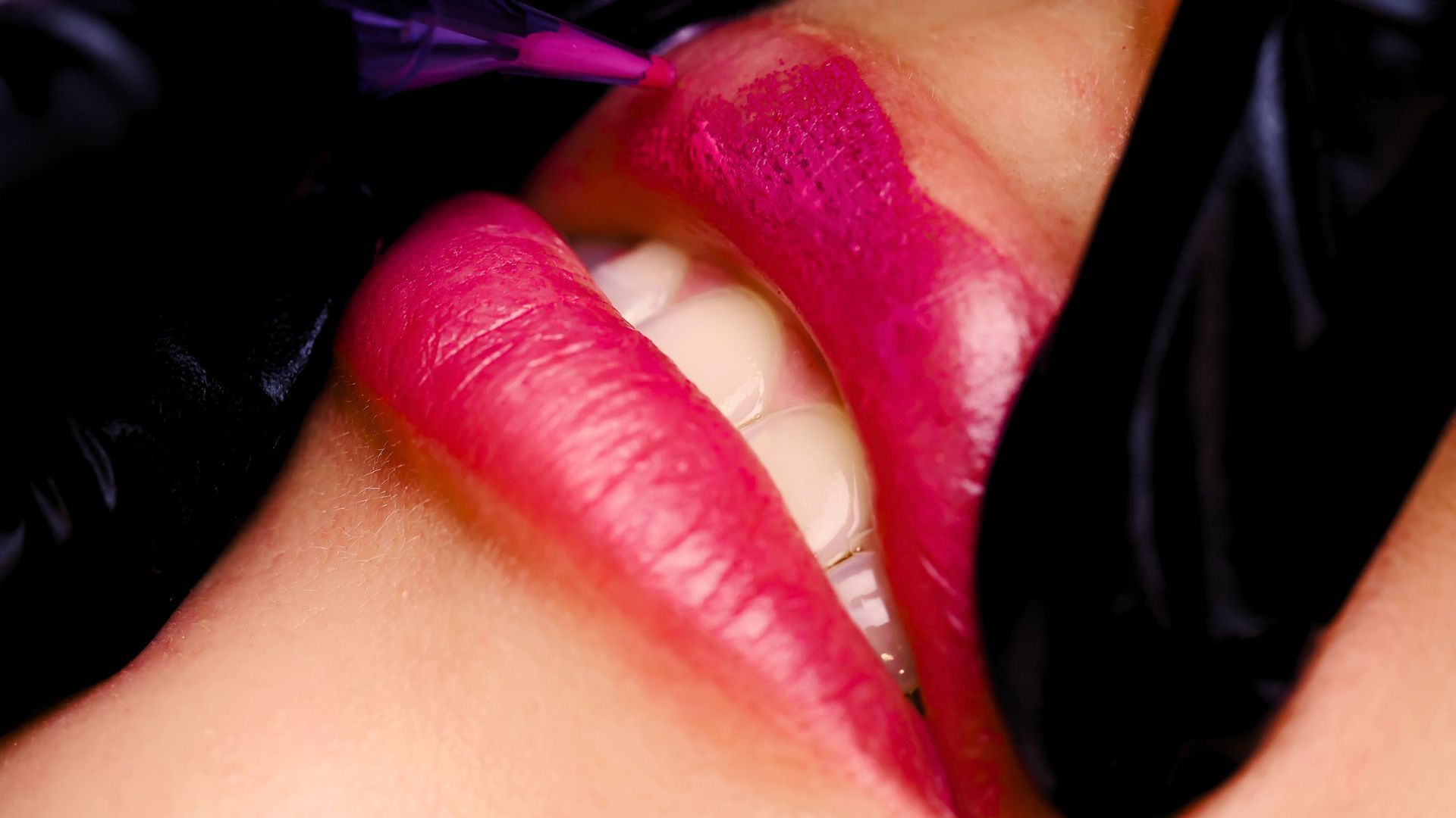 A close up of a woman 's lips with pink lipstick.