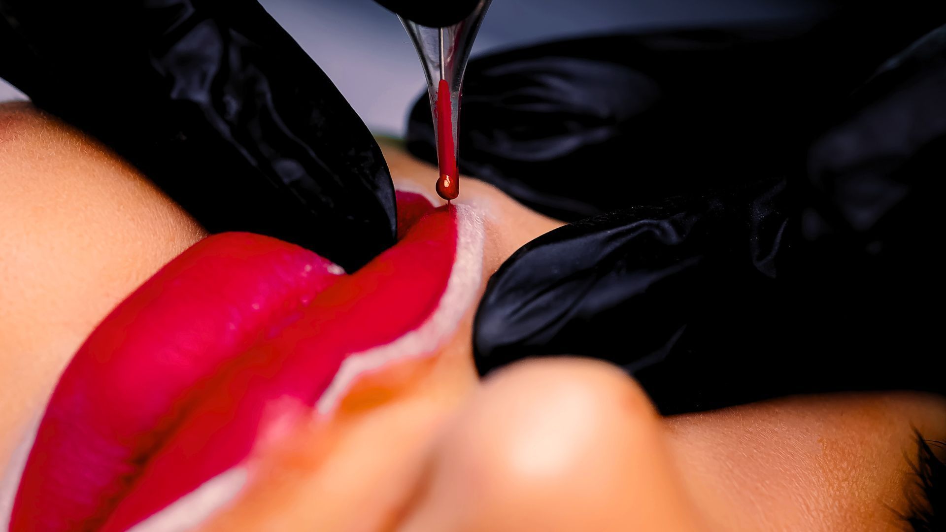 A close up of a woman's lips with pink lipstick tattoo.