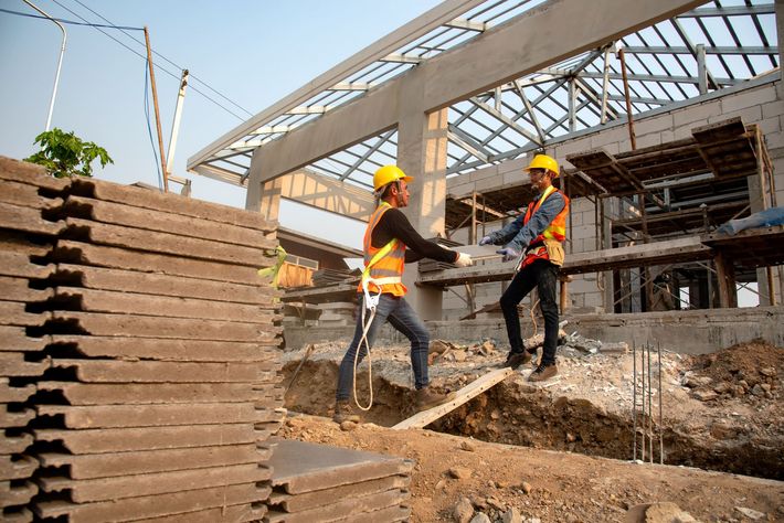 un uomo e una donna sono in piedi davanti a un cantiere edile