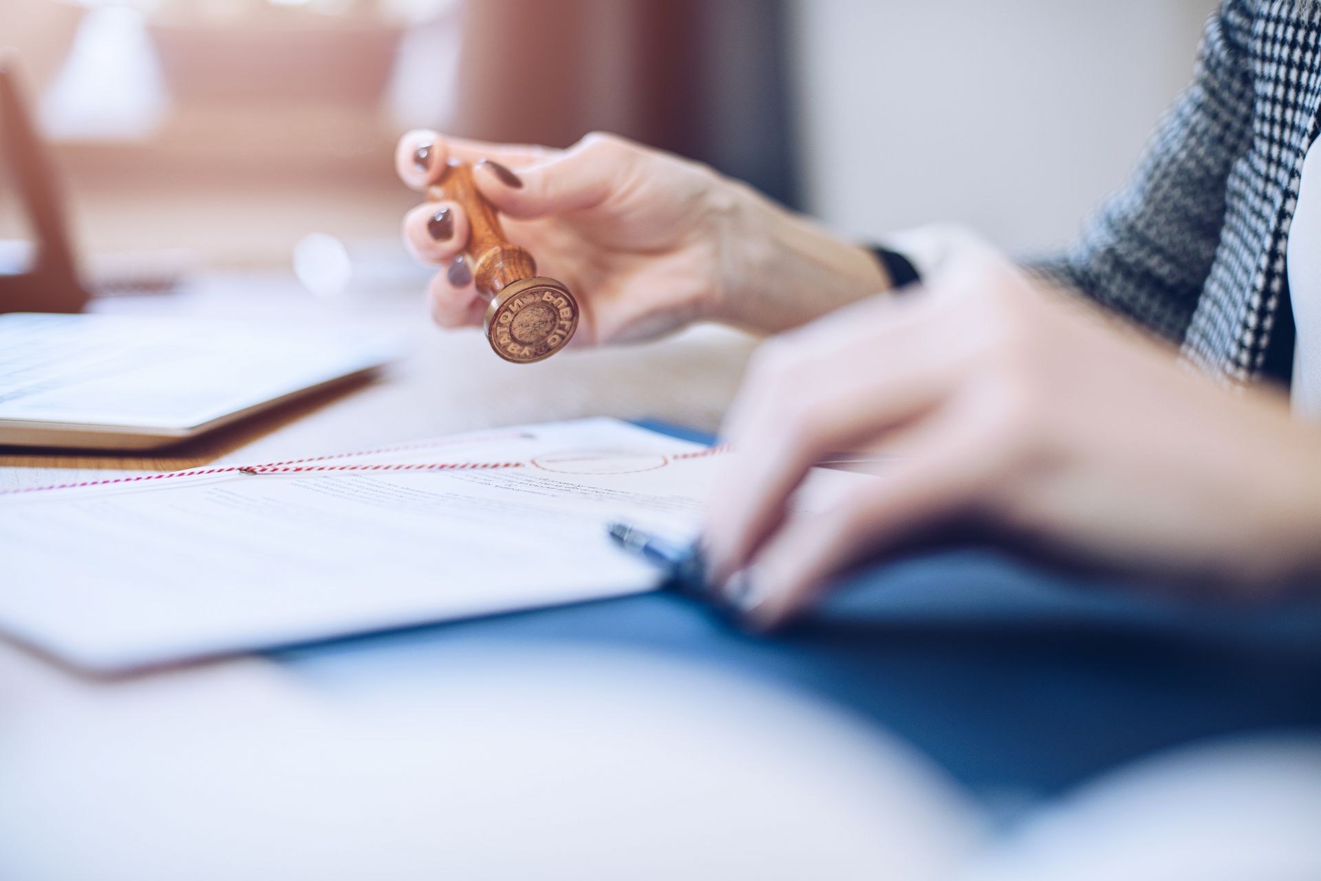 A woman is holding a stamp over a piece of paper.