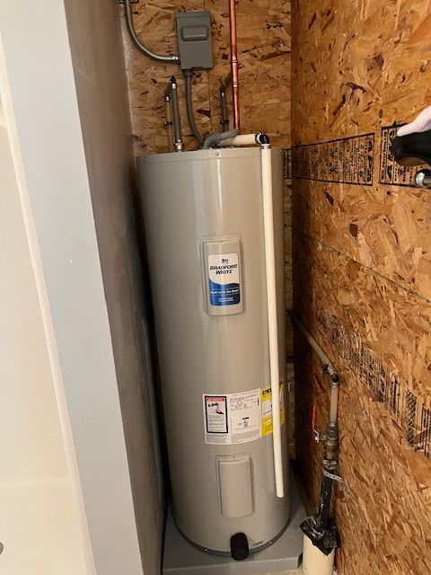 A water heater is sitting in a corner of a room.