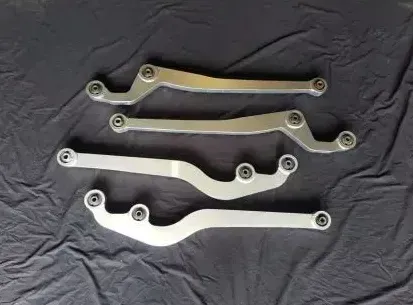 Four metal wrench-like tool arms laid horizontally on a dark cloth — Ironhide Customs In Garbutt, QLD