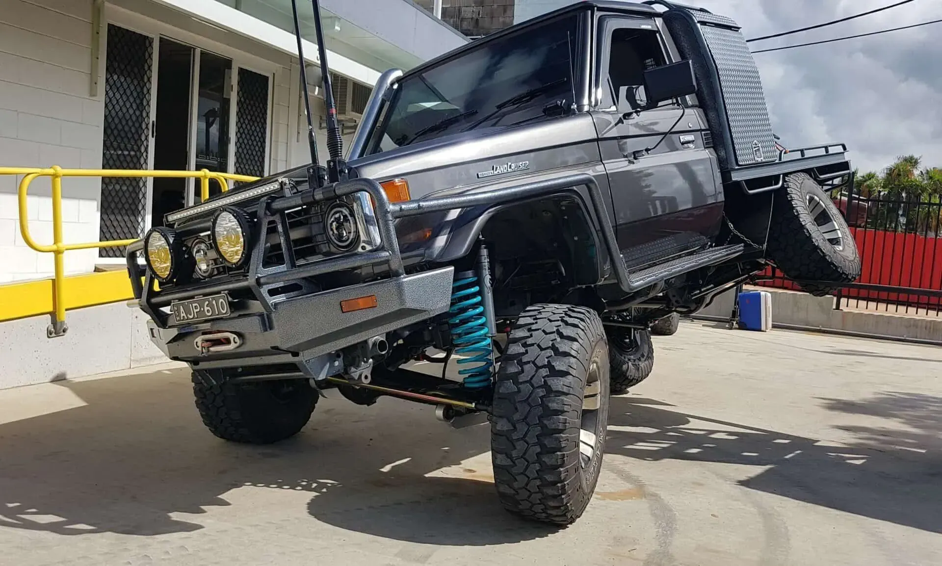 A Lifted Black Toyota Land Cruiser Pickup Truck Parked on A Concrete Lot — Ironhide Customs In Garbutt, QLD