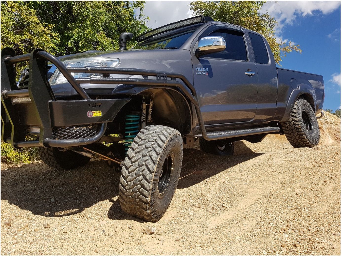 A White Toyota Hilux Truck with A Flatbed Tray — Ironhide Customs In Garbutt, QLD