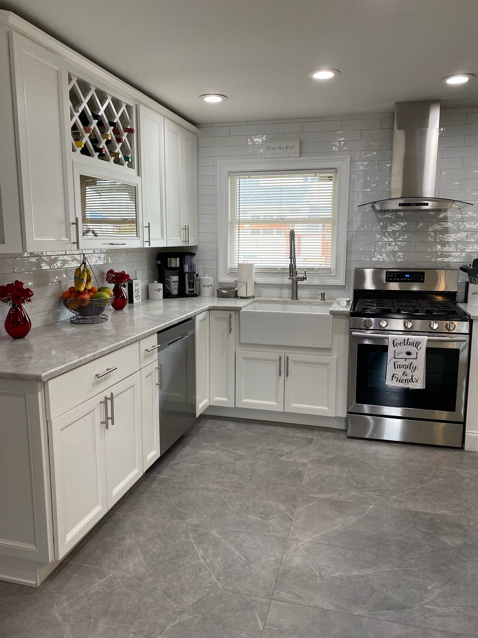 White kitchen with stainless steel appliances, white cabinets, and a farmhouse sink.