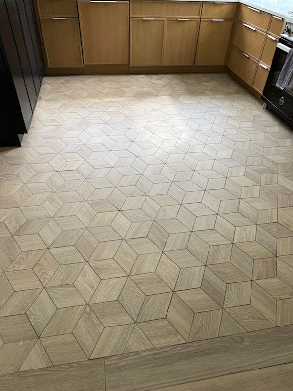Wooden kitchen floor with a repeating 3D cube pattern.